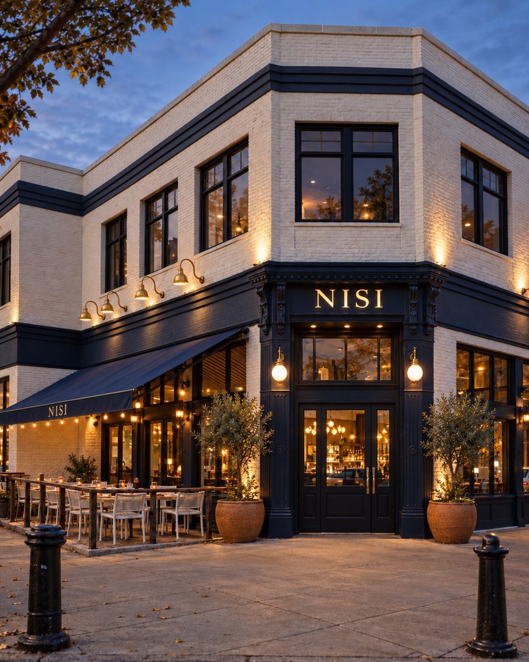Concept rendering of the Nisi building at dusk: cream brick, navy trim, the Nisi sign over the door and a patio under a navy awning