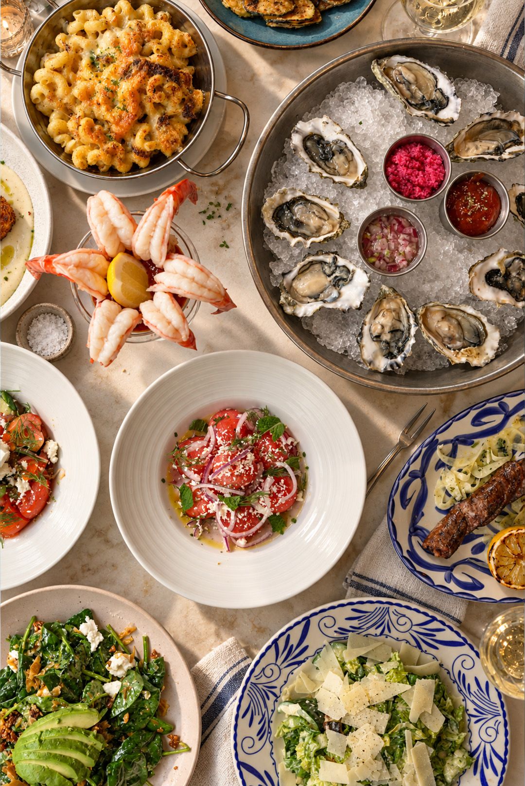 A table laid with shared dishes, oysters and a seafood platter