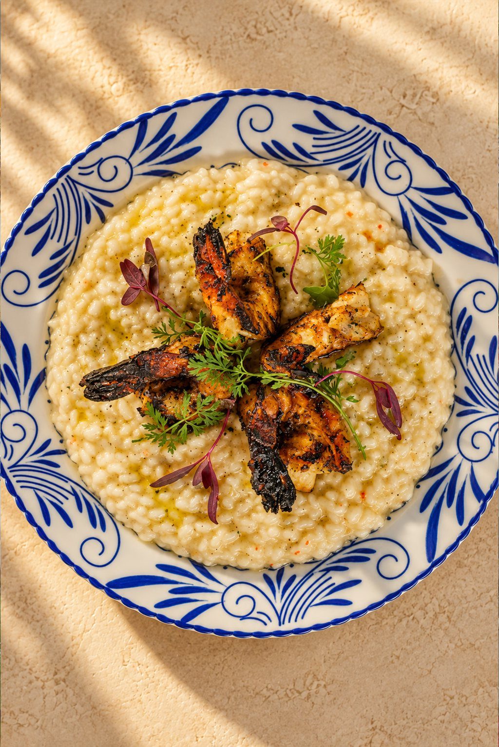 Avgolemono risotto with prawns on a blue and white plate